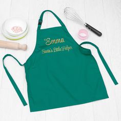 an apron with the name smma on it next to other kitchen accessories and utensils