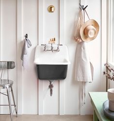 a white sink sitting under a mirror next to a wall mounted faucet in a bathroom