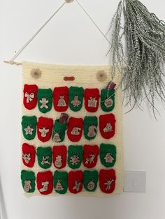 a knitted christmas stocking hanging on a wall next to a potted plant