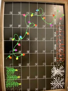 a calendar with christmas lights drawn on it and snowflakes hanging off the side