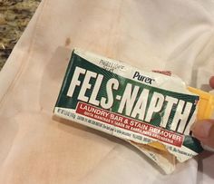 a hand holding a bar of fels - naph laundry bar and stain remover