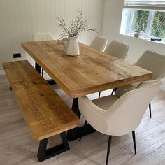 a wooden table with white chairs around it