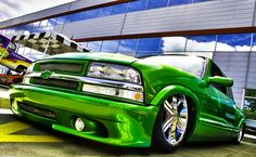 a green truck parked in front of a building