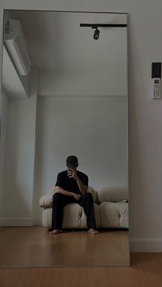 a man sitting on a couch in front of a mirror