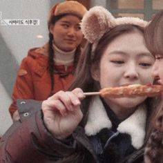 two girls are eating pizza while wearing ears