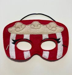 a red and white mask with black eyes