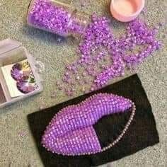 purple beads are on the ground next to a bag