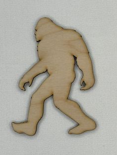 a wooden cutout of a bigfoot running on a white background with the text,