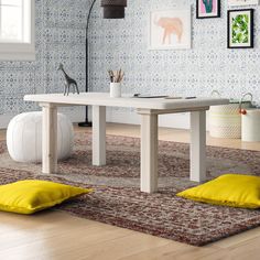 a white table sitting on top of a wooden floor next to a yellow bean bag