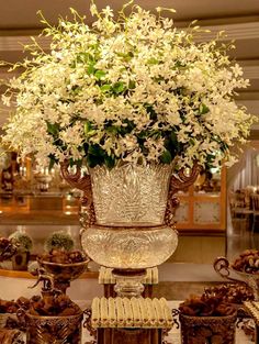 a large vase filled with white flowers sitting on top of a table next to other items