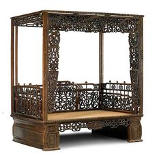 an ornate wooden bed frame with intricate carvings on the top and bottom sides, sitting against a white background