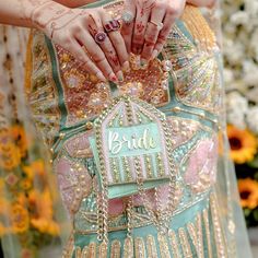 the brides hands are holding on to their wedding dress, which is decorated with beads and jewels