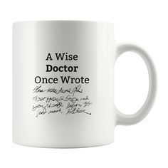 a white coffee mug with writing on the inside and bottom, which reads a wise doctor once wrote