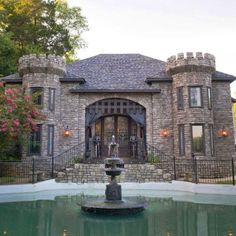 a large house with a fountain in front of it