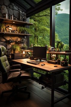 a desk with a computer on top of it in front of a window overlooking the mountains