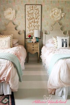 two twin beds in a room with floral wallpaper