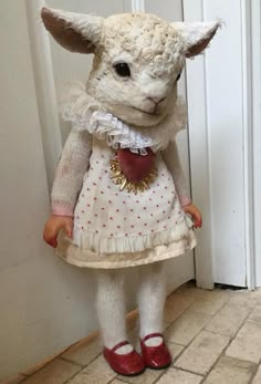 a stuffed animal wearing a white dress and red shoes standing in front of a door