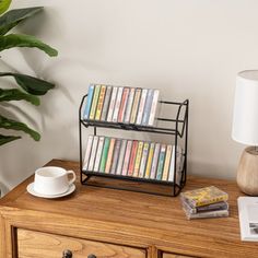 a book shelf with books on it next to a lamp and a potted plant