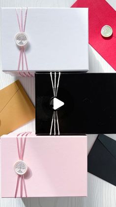 four different colored envelopes tied together with string and buttons on white wooden table top