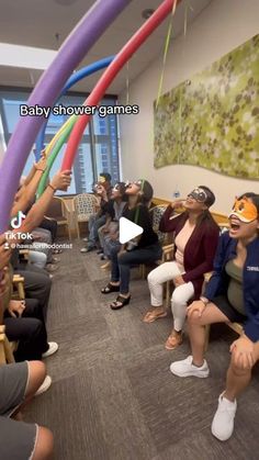 a group of people sitting around each other in a room with balloons and streamers