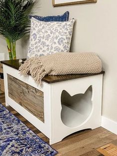 a wooden bench sitting on top of a hard wood floor next to a potted plant