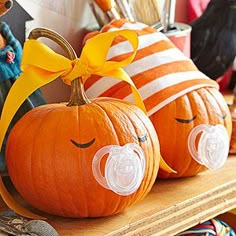 two pumpkins with pacifier attached to them sitting on a shelf in a store