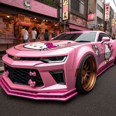 a pink car with hello kitty painted on it