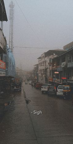 a street with cars parked on the side and people walking down it in the rain