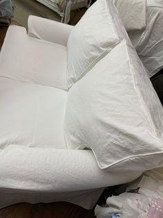 a pile of white pillows sitting on top of a wooden floor