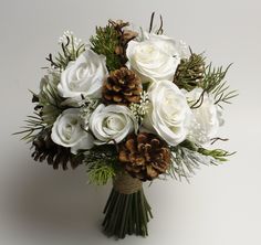 a bouquet of white flowers and pine cones