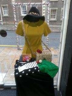 a woman's dress and purse on display in front of a window