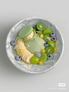 a white bowl filled with different types of fruits and cheese on top of each other