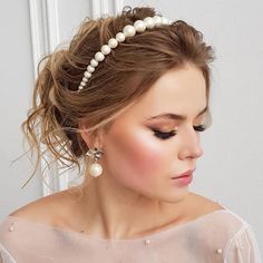 a woman in a white dress with pearls on her head, wearing a pearled hair comb