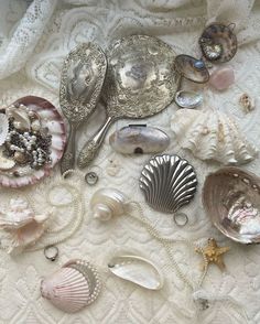 various seashells and silverware on a white tablecloth