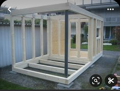 a house being built in the middle of a yard with wood framing on it's sides