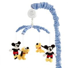 two stuffed animals hanging from a blue and white baby crib with mickey mouse on it