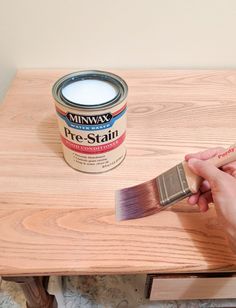 someone is painting a wooden table with white paint