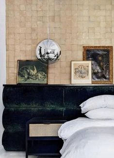 a bed sitting next to a green couch in a room with pictures on the wall