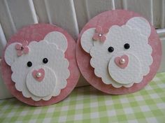 two pink and white sheep magnets sitting on top of a table