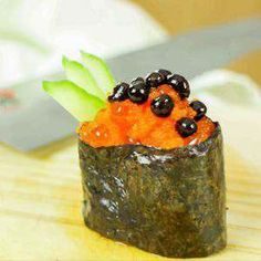 a small sushi with black olives on top