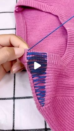 someone is sewing a sweater with a needle on the end and an arrow in the middle