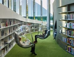 a person sitting in a swing chair next to a book shelf filled with lots of books