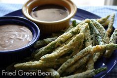 fried green beans and dipping sauce on a blue plate with a checkered tablecloth