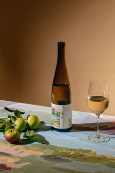 a bottle of wine and some fruit on a table