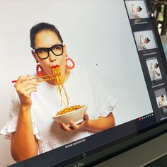 a woman eating noodles from a bowl on her computer screen