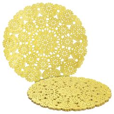 a yellow doily sitting on top of a white table next to another doily