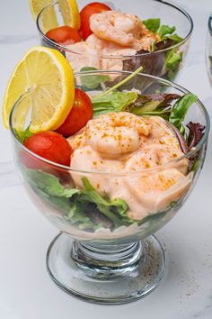 two glass bowls filled with salad and shrimp