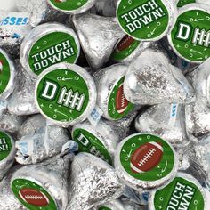 a pile of silver foil wrapped candy with football stickers on them