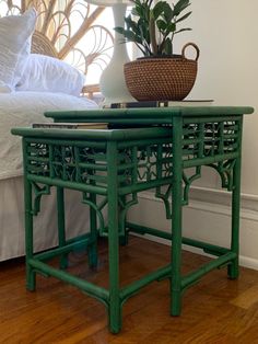 two green side tables sitting on top of a hard wood floor next to a bed