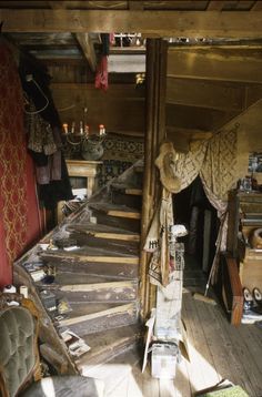 the inside of an old house with wooden floors and walls covered in carpeted furniture